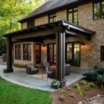 an outdoor living area with patio furniture and stone pavers flooring in front of a brick house