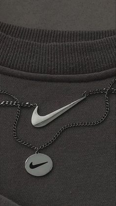 the nike logo is attached to a t - shirt that has a chain on it