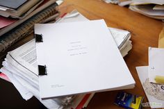 a pile of papers sitting on top of a wooden table