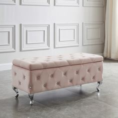 a pink bench sitting on top of a floor next to a white wall and windows