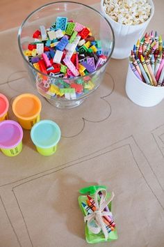 the table is covered with plastic cups and candy