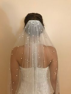 the back of a bride's veil with pearls on it