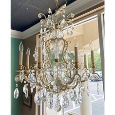 a chandelier hanging from the ceiling in front of a window