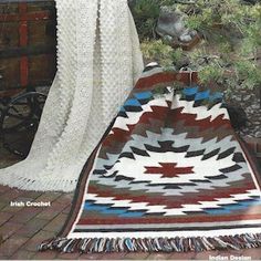 a woman standing next to a blanket on top of a brick floor in front of a potted plant