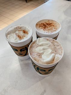 three cups of coffee with whipped cream on top