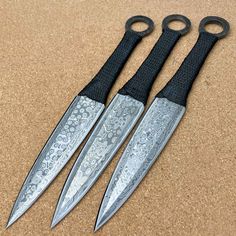 two knives with black handles are sitting on the ground