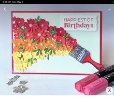 a close up of a paintbrush with flowers on it next to some coins and paper