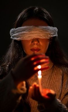 a woman holding a lit candle in her hands