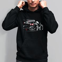 a man wearing a black hoodie with a car drawn on it