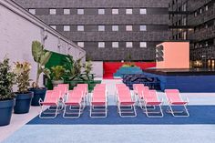 rows of red and blue chairs sitting next to each other in front of a building