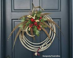 a wreath with antlers and berries hanging on the front door to decorate it for christmas