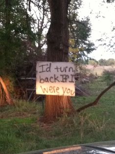 a sign that reads i'd turn back and we're you next to a tree