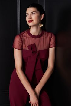 a woman in a red dress sitting down