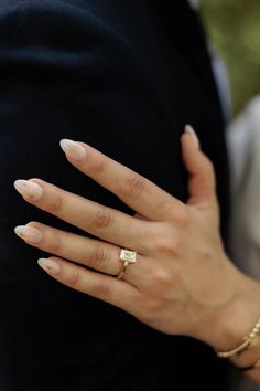 a close up of a person's hand with a ring on their left finger