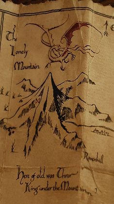 a piece of parchment paper with an image of a dragon and mountains in the background