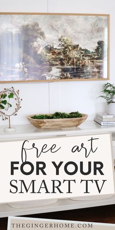 a white table topped with a bowl of green plants and a sign that says free art for your smart tv