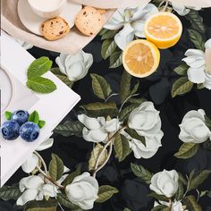 a table topped with blueberries and oranges on top of a table covered in flowers