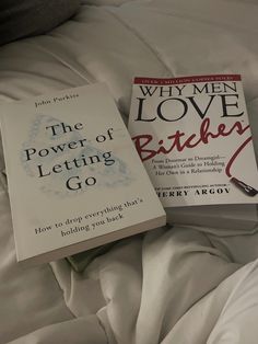 two books sitting on top of a bed next to each other in front of the covers