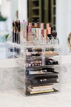 a clear makeup organizer on top of a counter