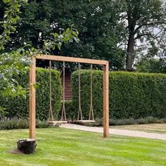 a wooden swing set in the middle of a garden