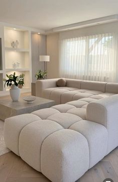 a living room filled with furniture and a large white couch in front of a flat screen tv