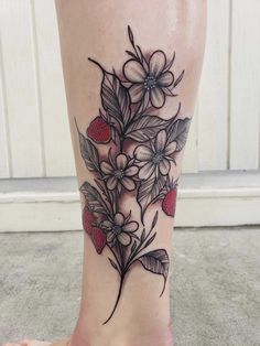 a woman's foot with flowers and leaves on the bottom part of her leg