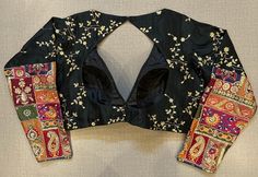 Beautiful black embroidered saree blouse with multi patch sleeves. Buy designer blouse in USA from Pure Elegance. Disclaimer: The actual product may vary slightly from the image. These are custom orders, hence expect slight variation in color, placement of the motif or buta. ESTIMATED DELIVERYBecause this is a custom order, it would take about 4 weeks from the date of purchase. RETURN POLICY: This product is a custom order and cannot be returned or exchanged. Black Embroidered Traditional Drape Blouse, Traditional Drape Embroidered Black Blouse Piece, Black Embroidered Blouse Piece, Fitted Blouse With Multicolor Embroidery For Festivals, Multicolor Long Sleeve Blouse Piece With Motifs, Designer Fitted Multicolor Blouse Piece, Designer Embroidered Black Blouse Piece, Black Embroidered Designer Blouse Piece, Semi-stitched Black Blouse With Motifs