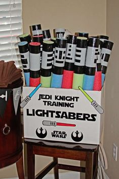 star wars training lightsabes are in a box on a stool next to a window