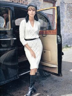 a woman in a white dress and black boots leaning out the door of a car