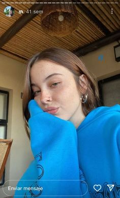 a girl in a blue hoodie looking at the camera