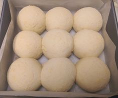 six balls of dough in a box ready to be baked