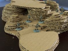 several pieces of cardboard are stacked on top of each other with small blue pins in the middle