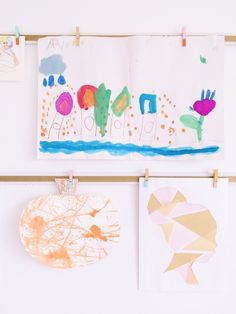 children's artwork hangs on the wall next to their drawings