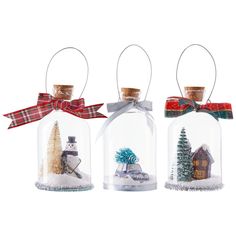 three snow globes with christmas decorations inside them on a white background, one is empty and the other has a bow