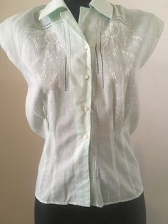 This is a lovely feminine sleeveless blouse!  Mint green sleeveless blouse with white embroidery and open work on front placket.  Very fine cotton, beautifully crafted.  Excellent vintage condition, no issues. No tag. Size: US Small Waist: 15" - flat, seam to seam Length: 23" - flat, collar to cuff  Bust: 16.5" - flat, seam to seam Vintage Sleeveless Blouse For The Beach, Green Summer Blouse With Chikankari Embroidery, Green Blouse With Chikankari Embroidery For Summer, Green Chikankari Embroidery Blouse For Summer, Summer Daywear Tops With Chikankari Embroidery, Summer Tops With Chikankari Embroidery For Daywear, Summer Chikankari Embroidery Tops For Daywear, Green Chikankari Embroidery Top For Summer, Classic Summer Blouse With Floral Embroidery