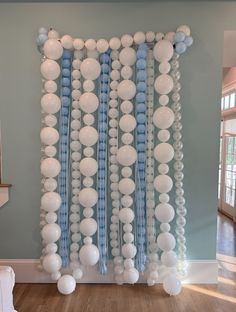 balloons and streamers are hanging from the ceiling in front of a blue - gray wall