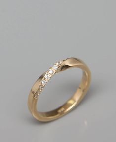 a yellow gold wedding ring with three diamonds