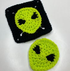 two crocheted smiley faces sitting next to each other