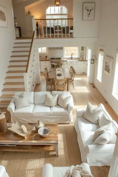 a living room filled with white furniture next to a staircase