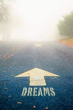 an arrow painted on the road that says dreams