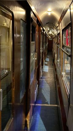 the inside of a train car with many windows on each side and doors open to let in light