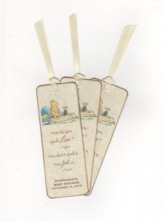 three tags with winnie the pooh sayings hanging from strings on a white background