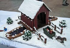 a cake that looks like a farm scene with people and animals in the snow on it