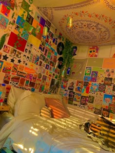 a bed with lots of pictures on the wall above it and a lamp hanging from the ceiling