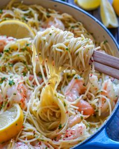 the pasta is being lifted from the pan with lemons and parmesan cheese