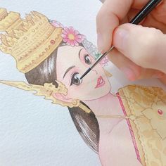 a woman is drawing on paper with colored pencils