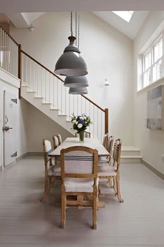 a dining room table and chairs under a stair case