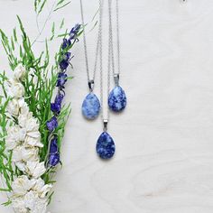 This necklace is made from a sodalite stone which has been cut into a teardrop. The stone hangs from a silver plated chain. You can choose the length of the necklace you prefer. You will get a necklace at random. Please note that all necklaces are handmade and may differ from the pictured. The picture shows multiple necklaces. You will receive one necklace with one pendant. Ewelina Pas Jewelry Silver Teardrop Necklace With Gemstone Beads, Silver Teardrop Crystal Necklace With Natural Stones, Blue Teardrop Stone Necklace, Lapis Lazuli Teardrop Necklace For Gift, Teardrop Lapis Lazuli Necklace For Gift, Blue Teardrop Pendant Jewelry With Large Stone, Silver Sodalite Necklace With Natural Stones, Sodalite Pendant Necklace For Gift, Multiple Necklaces