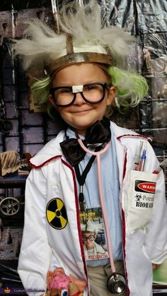 a young boy dressed up as a doctor with green hair and eyeglasses on