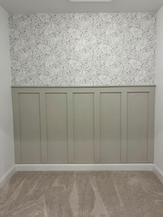 empty room with wallpaper and carpeting in the corner, including an open door